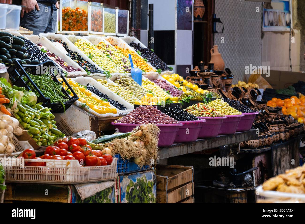 Meknes, Marocco: Vivace esposizione di spezie colorate disposte in pile coniche in un tradizionale suk marocchino. L'immagine mostra texture ricche e h Foto Stock