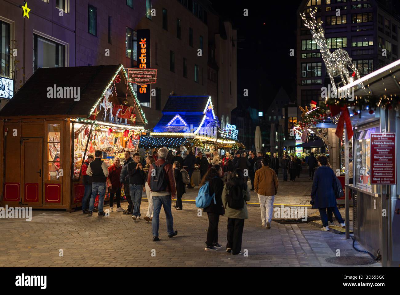 Nürnberger Weihnachtsbeleuchtung 2025, Nürnberg, 13.11.2025 Besucherinnen und Besucher schlendern am Abend über den festlich beleuchteten Weihnachtsmarkt am Ludwigsplatz in der Nürnberger Altstadt. Mehrere Verkaufsstände mit Süßwaren und Geschenkartikeln sind weihnachtlich geschmückt. Die festliche Beleuchtung ist Teil der städtischen Aktion Nürnberg leuchtet. Nürnberg Bayern Deutschland *** Norimberga luci di Natale 2025, Norimberga, 13 11 2025 visitatori passeggiano attraverso il mercatino di Natale illuminato festosamente a Ludwigsplatz nel centro storico di Norimberga in serata diverse bancarelle che vendono confec Foto Stock