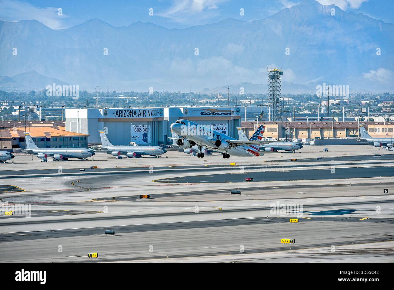 American Airlines A321 si solleva dalla pista di fronte all'Arizona National Guard Center presso l'aeroporto internazionale Skyharbour di Phoenix in Arizona, Stati Uniti Foto Stock