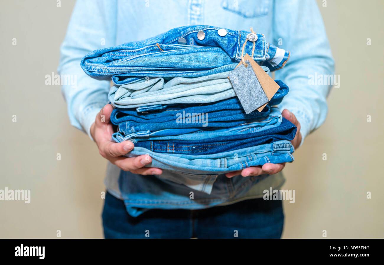 Donna pieghevole jeans eleganti su sfondo rosa, primo piano Foto Stock