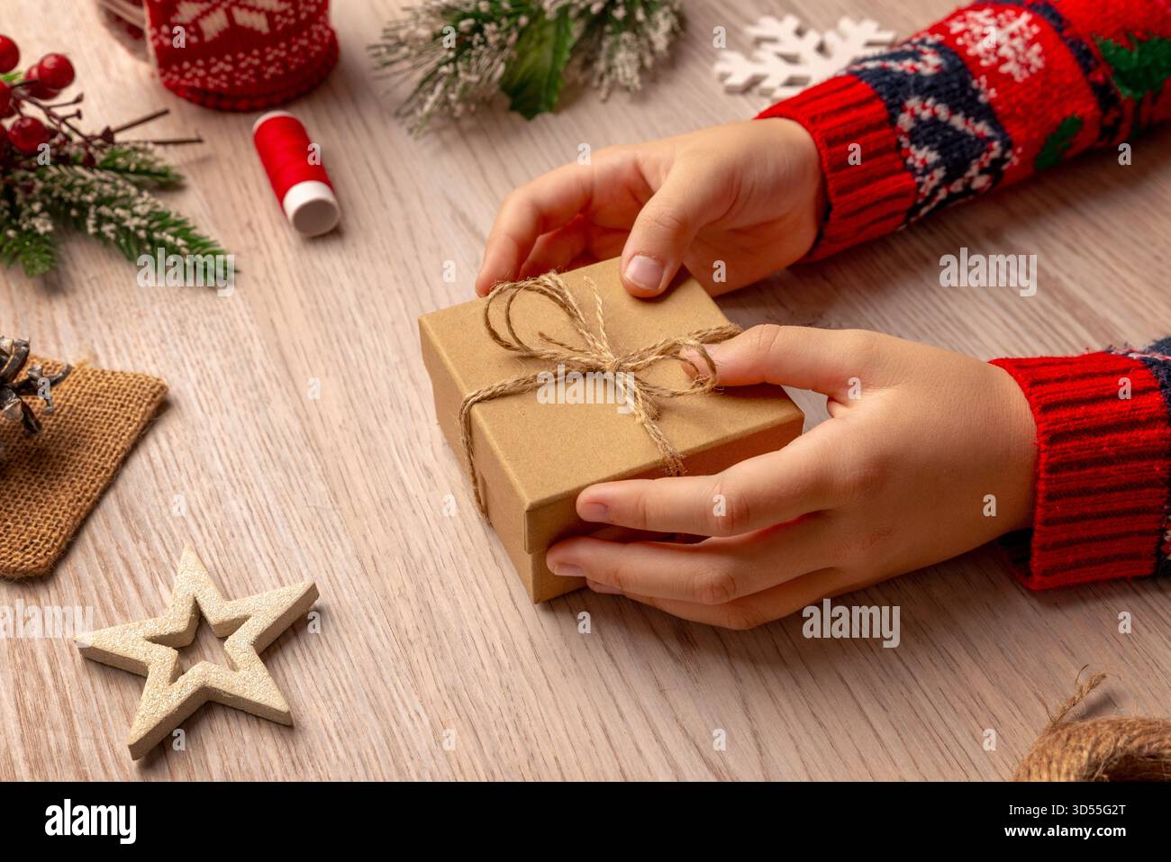 Confezione regalo ecologica avvolta da spago tra decorazioni natalizie naturali, ideale per concept di imballaggio sostenibili e marchi di prodotti fatti a mano Foto Stock