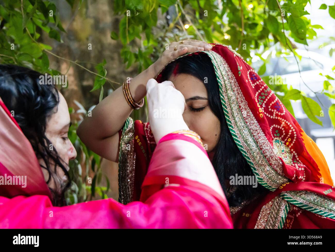 donna indù che esegue il rituale sacro vermiglio al chhath puja Foto Stock
