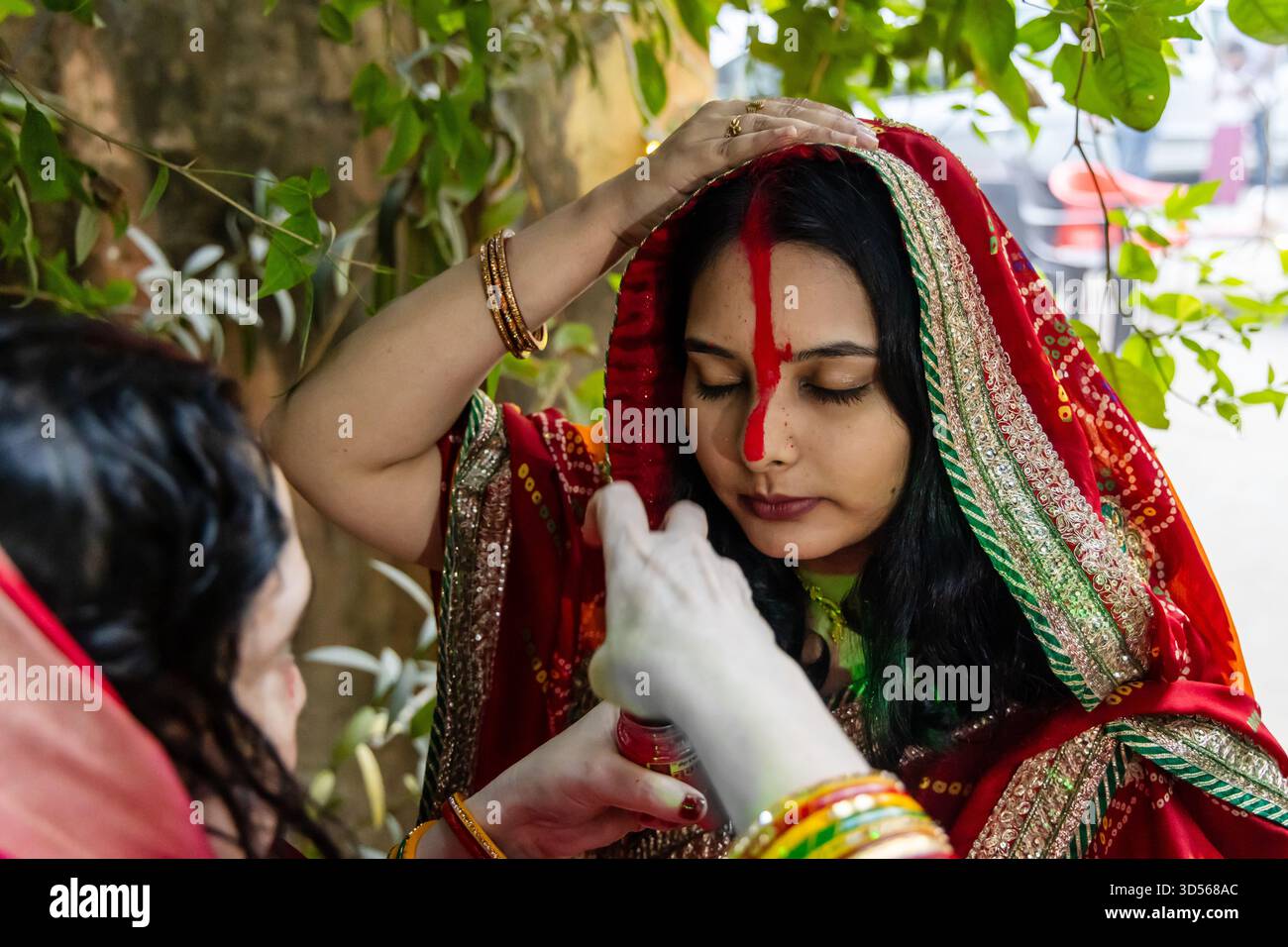 devoto che esegue rituali sacri sindoor o vermiglio durante la celebrazione del chhath puja Foto Stock
