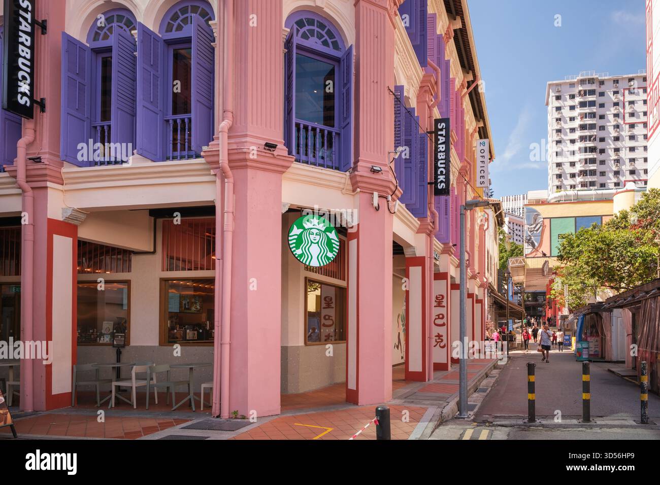 Singapore, Singapore - 3 ottobre 2025: Strade vivaci mostrano edifici di colore pastello Starbucks con un'architettura sorprendente. Le persone passeggiano, si divertono Foto Stock
