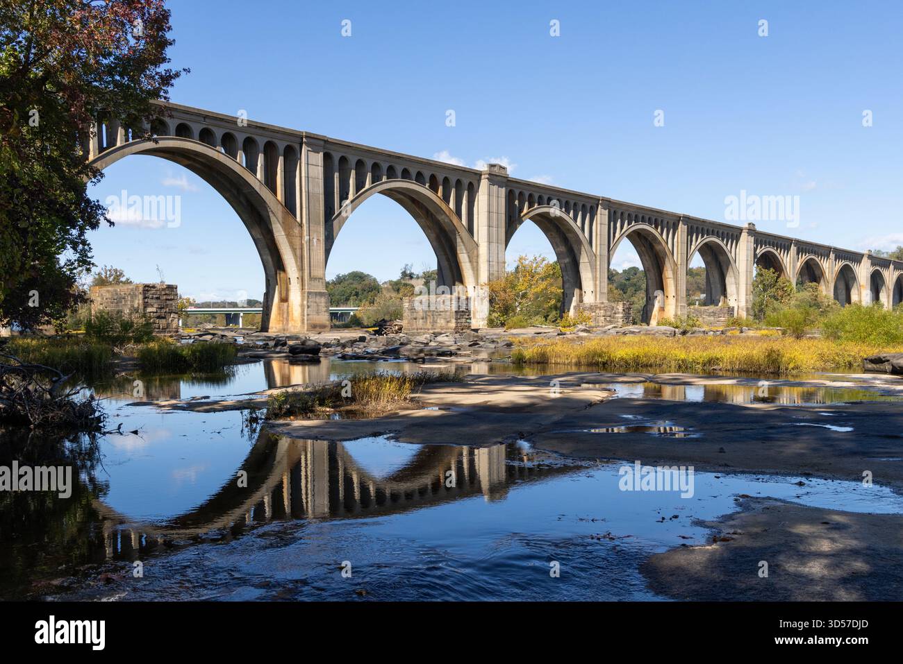 Ponte ad arco in cemento riflesso nel fiume James Foto Stock