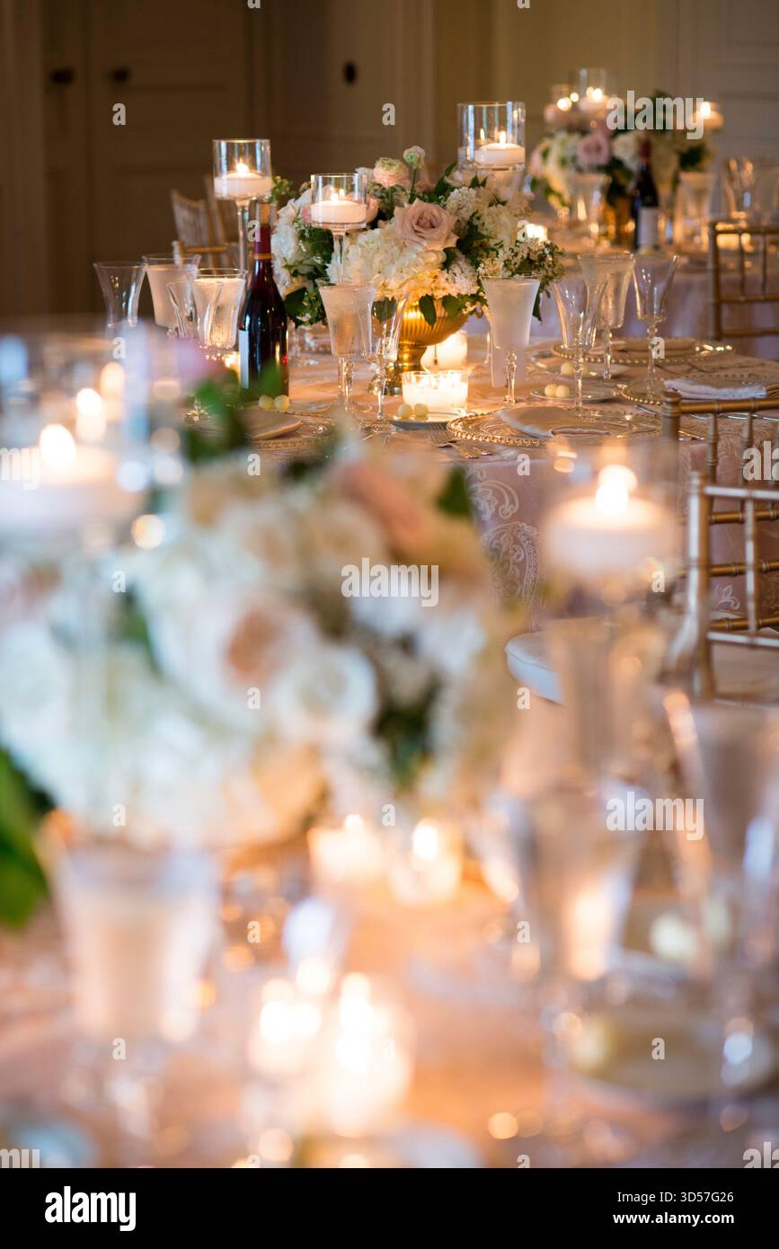 Elegante tavolo da ricevimento per matrimoni a lume di candela con centro floreale Foto Stock