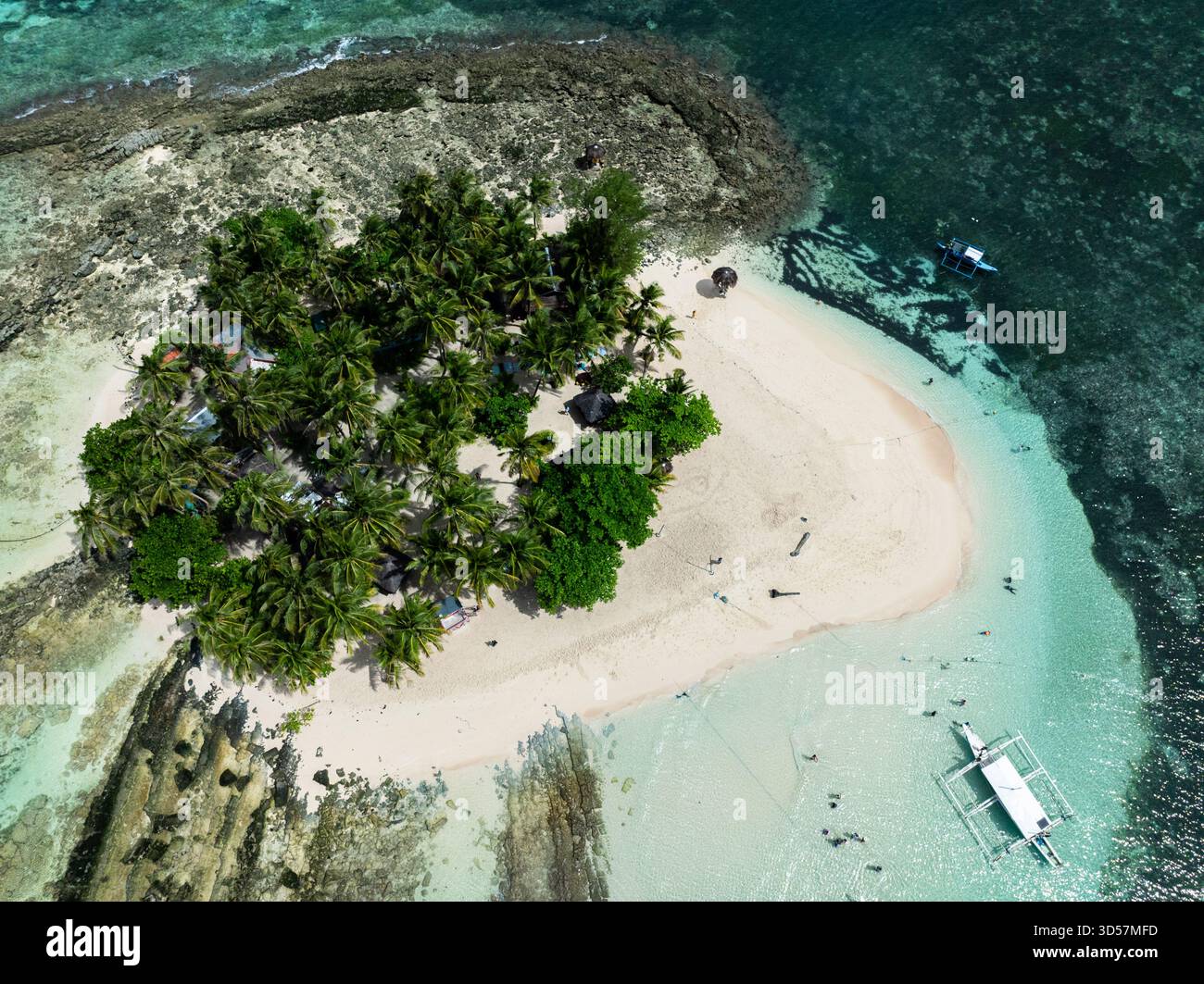 Vista dall'alto dell'isola con palme e spiaggia di sabbia circondata da acque turchesi e barriera corallina. Isola di Guyam. Siargao, Filippine. Foto Stock