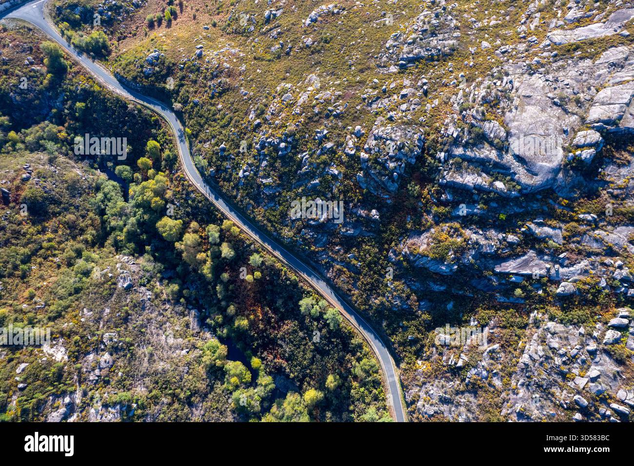 Una strada solitaria asfaltata attraverso un passo di montagna roccioso e aspro. Foto Stock