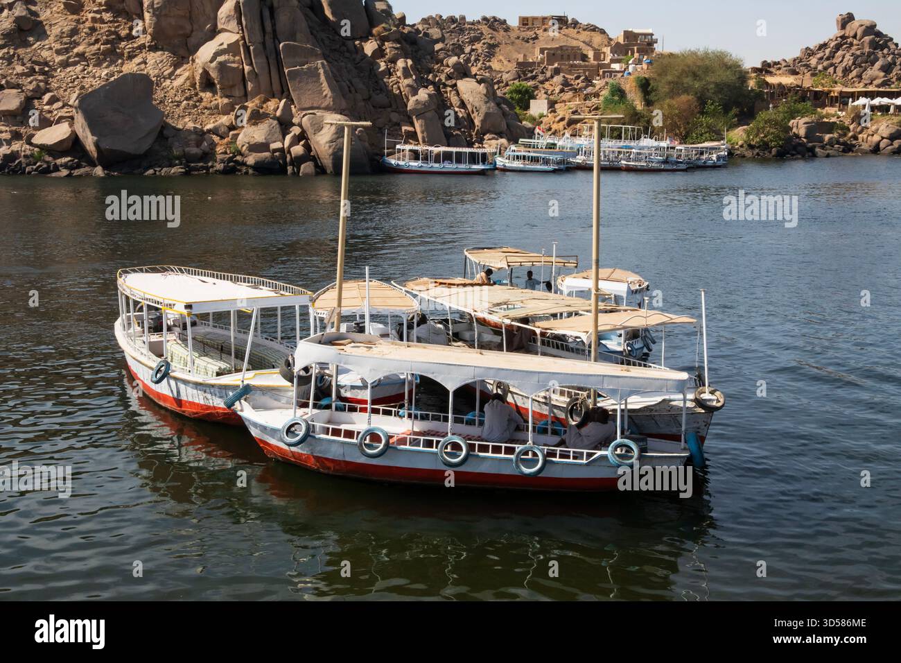 Barche colorate e turistiche all'ancora, in attesa che i turisti tornino dal Tempio di Philae, Assuan, Egitto. Foto Stock