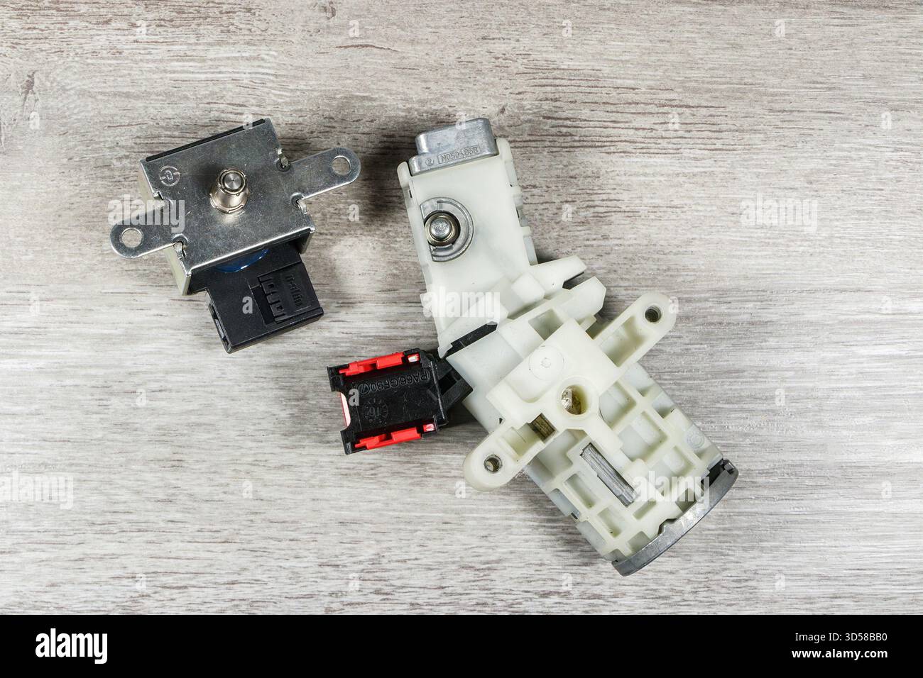 Primo piano di un commutatore di accensione per autoveicoli con connettori elettrici posizionati su una superficie di legno Smart Fourtwo Foto Stock