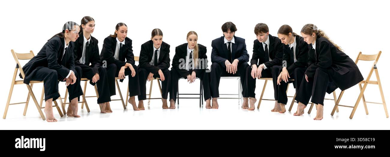Il team aziendale è seduto in cerchio e si piega in avanti con un'attenzione tesa e un'attesa silenziosa. Banner Foto Stock
