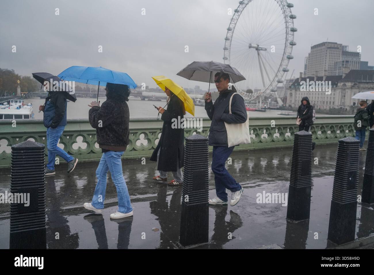 14 novembre 2025 pedoni che si rifugiano con ombrelloni sul ponte di Westminster credito: amer ghazzal/Alamy Live News Foto Stock