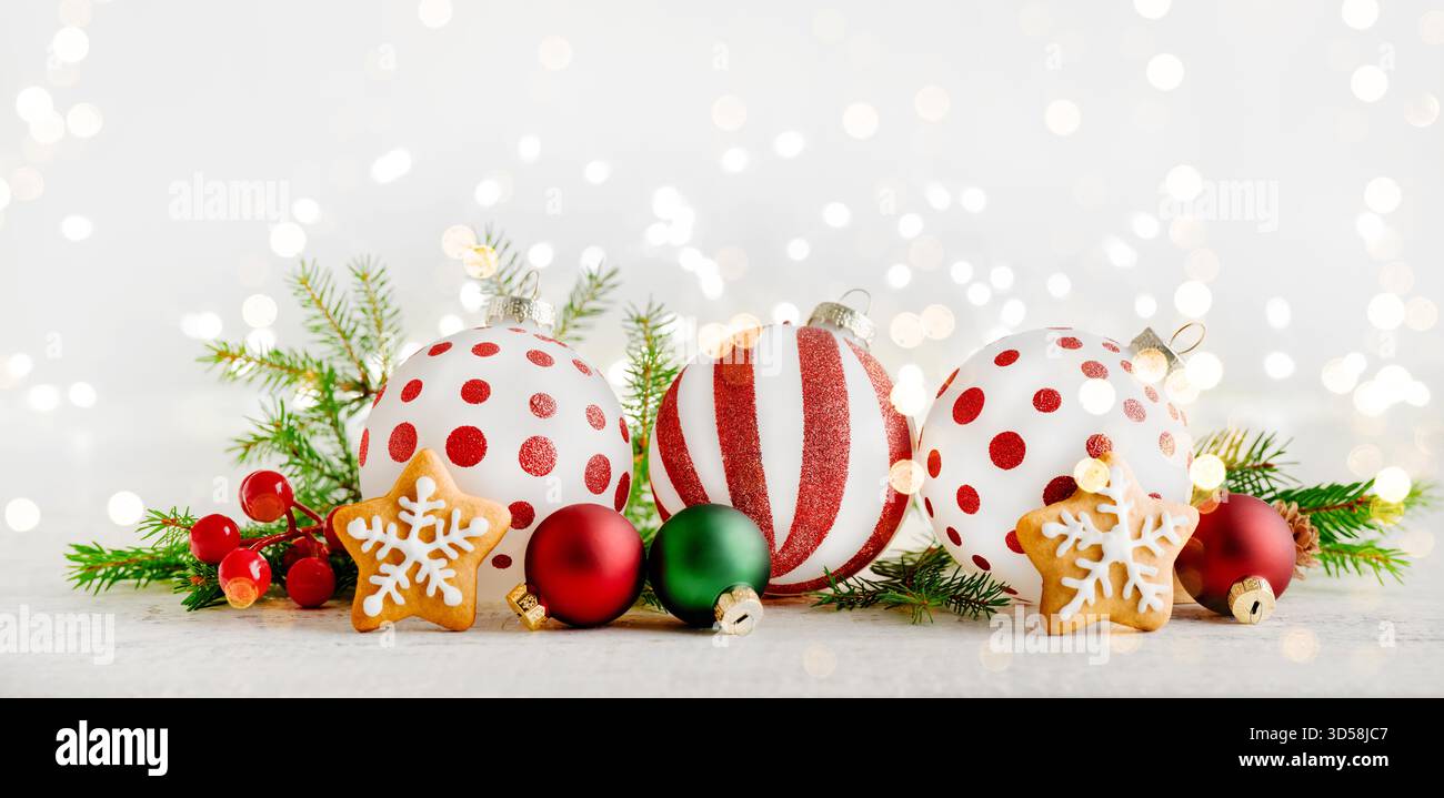 Biscotti stellati di pan di zenzero di Natale, decorazioni natalizie rami di alberi di Natale, regali e giocattoli su sfondo in legno con luce bokeh garland . Elemento di design del biglietto di Natale. Banner. Foto Stock