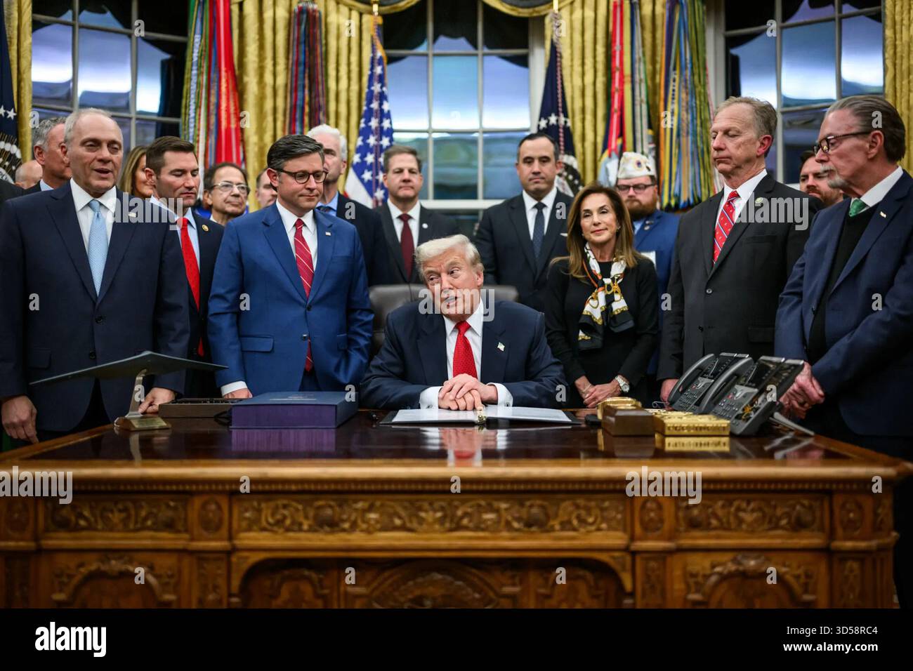 Il presidente Donald J. Trump parla prima di firmare il disegno di legge per riaprire il governo degli Stati Uniti nell'Ufficio ovale, circondato da funzionari applaudenti. Washington, D.C., 12 novembre 2025. Per gentile concessione della Casa Bianca. Foto Stock