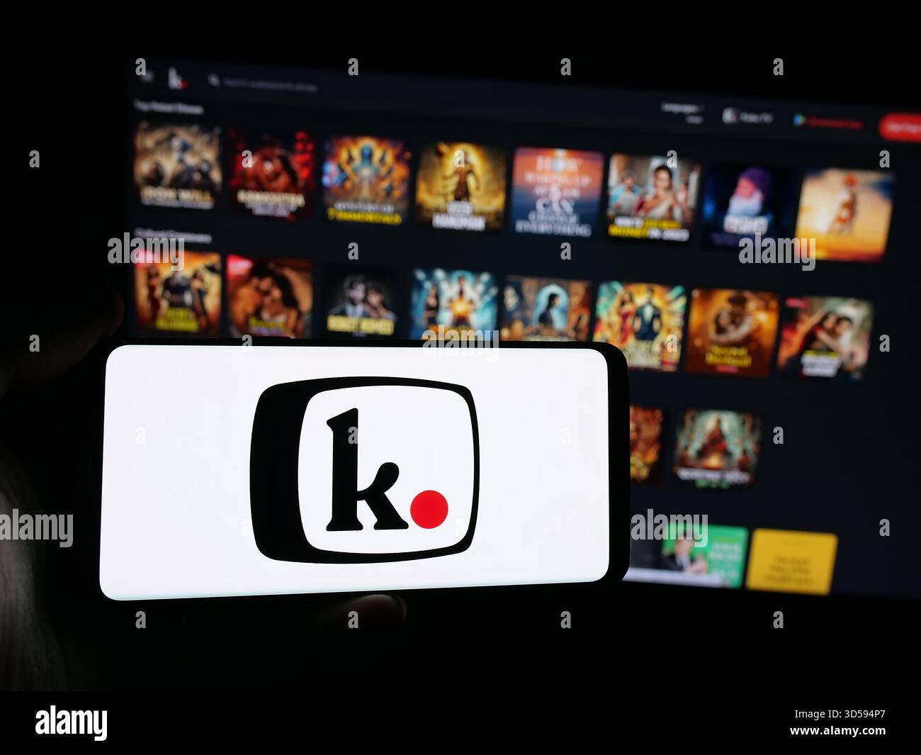 Stoccarda, Germania - 11-03-2025: Persona che possiede uno smartphone con il logo della società di piattaforme indiana Kuku FM (kukufm.com) sullo schermo davanti al sito web. Fil Foto Stock