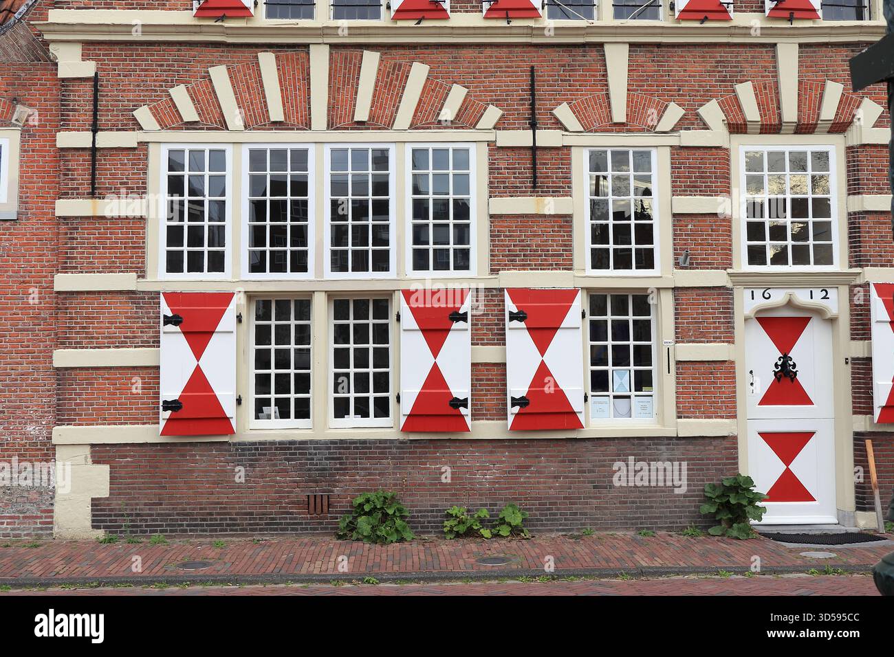 Facciata del vecchio edificio in mattoni con tende bianche e rosse a Leida, Kort Galgewater, Paesi Bassi, novembre 2025 Foto Stock