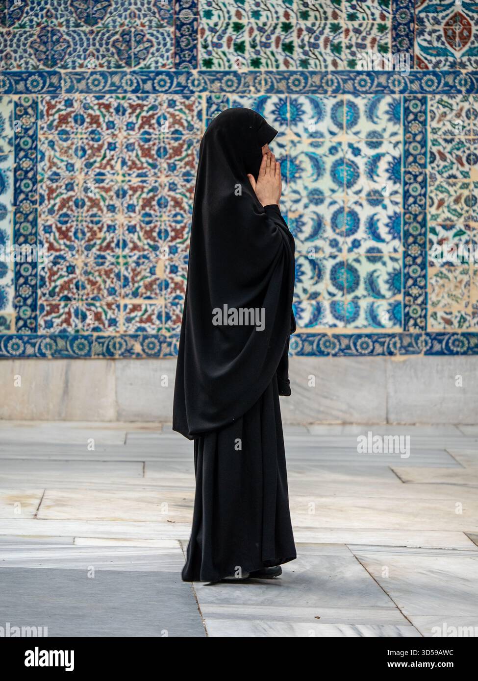 Volti di Turkiye (Turchia): Donna in tradizionale Burka nero prega Foto Stock