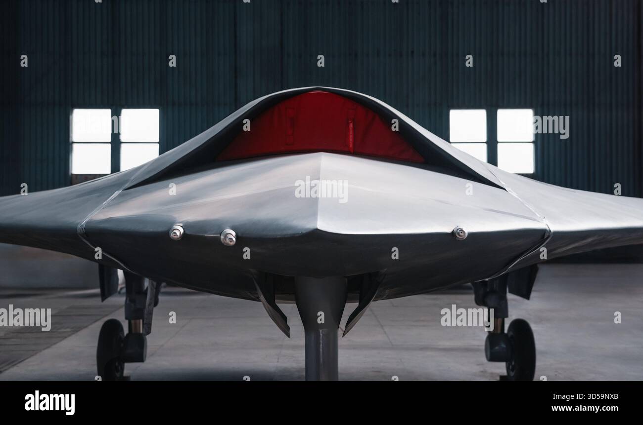 Vista frontale del drone stealth. Aerei militari senza equipaggio nell'hangar. Parte anteriore del drone grigio satinato con presa d'aria bloccata con coperchio rosso. Foto Stock