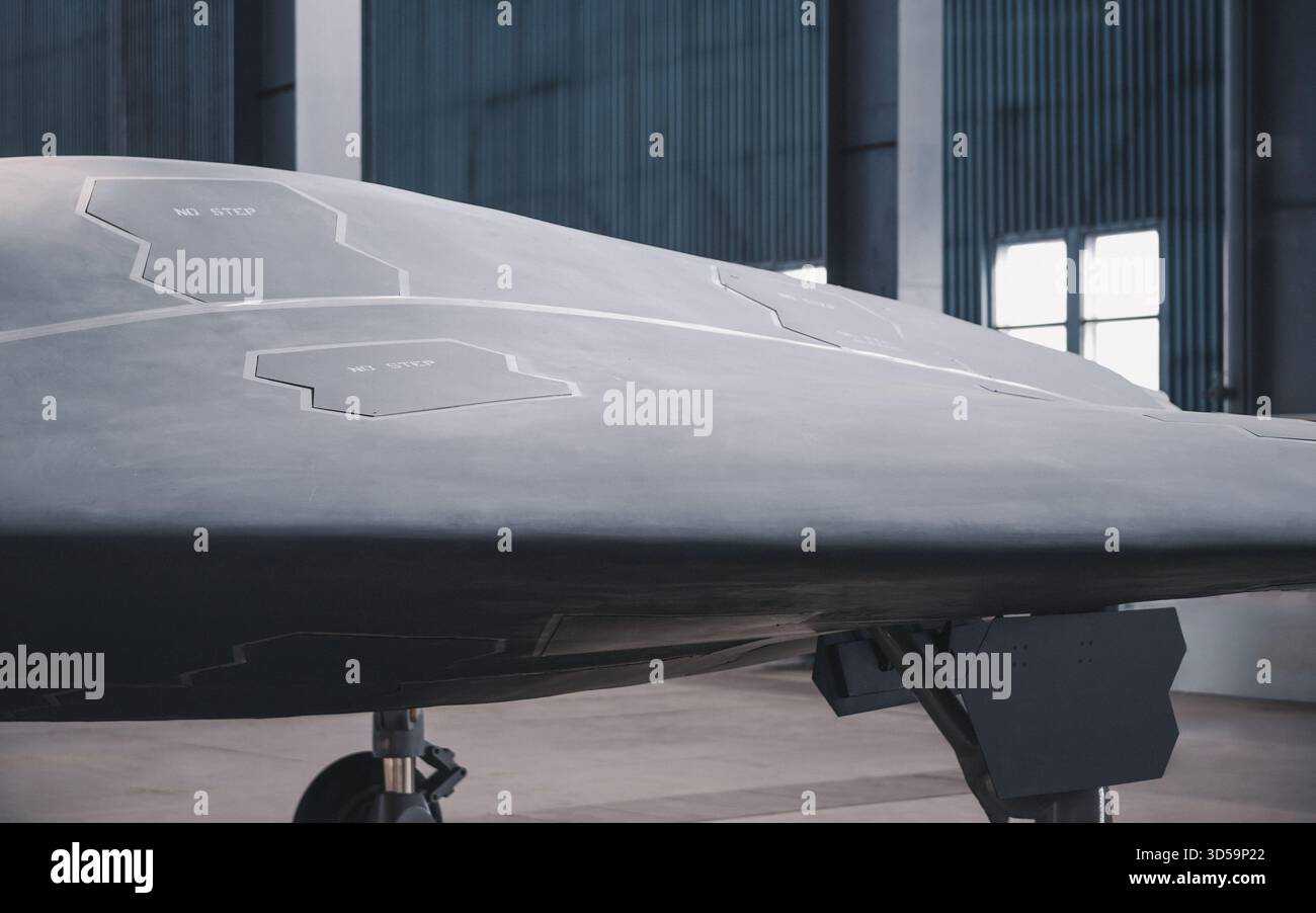 Aereo militare stealth nell'hangar. Parte laterale del drone ricoperta di vernice grigio satinato, frase "no step" scritta sulle alette di apertura sulla fusoliera. Foto Stock