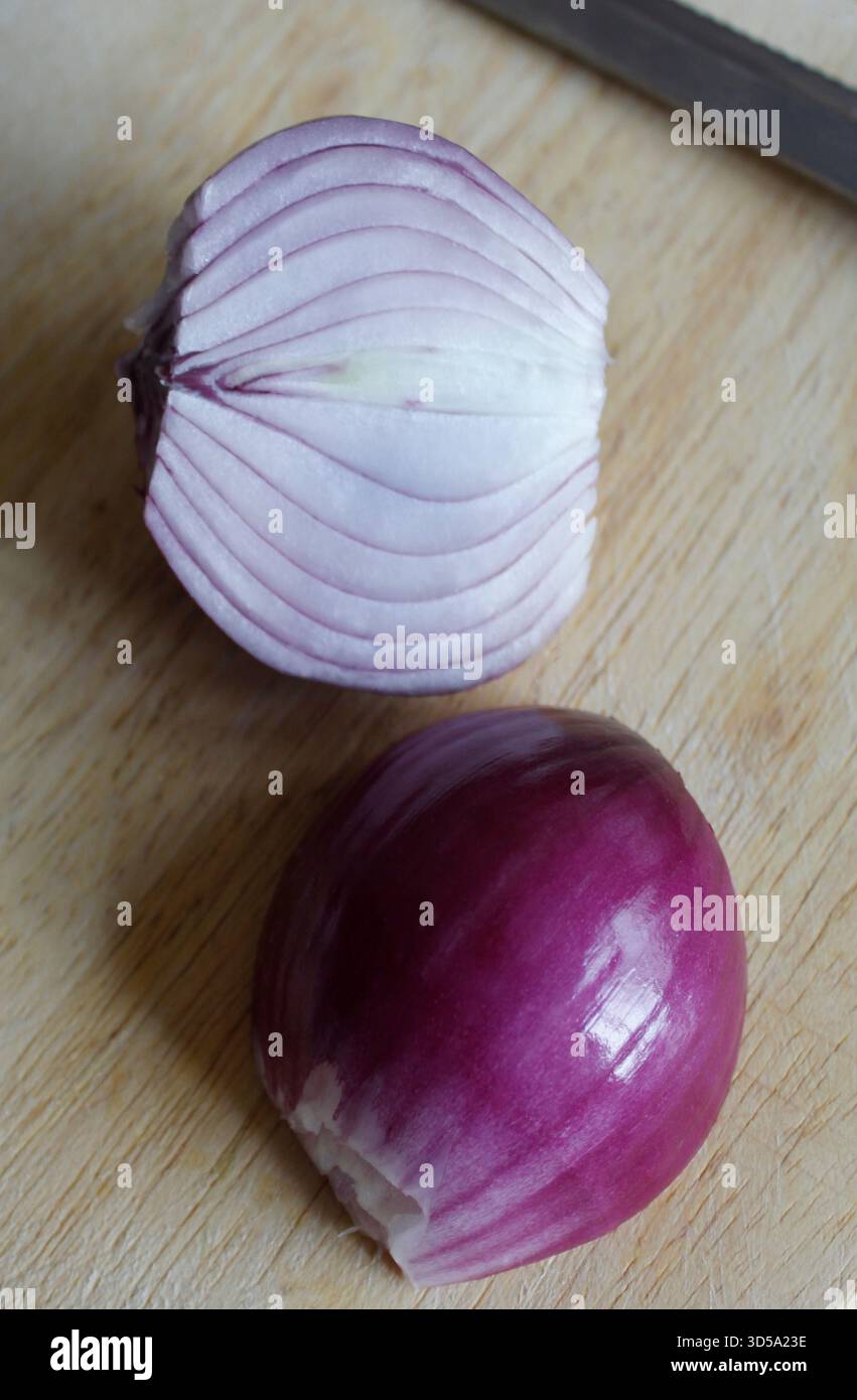 Cipolla rossa fresca coltivata in casa, tagliata a metà, pronta per la cottura Foto Stock