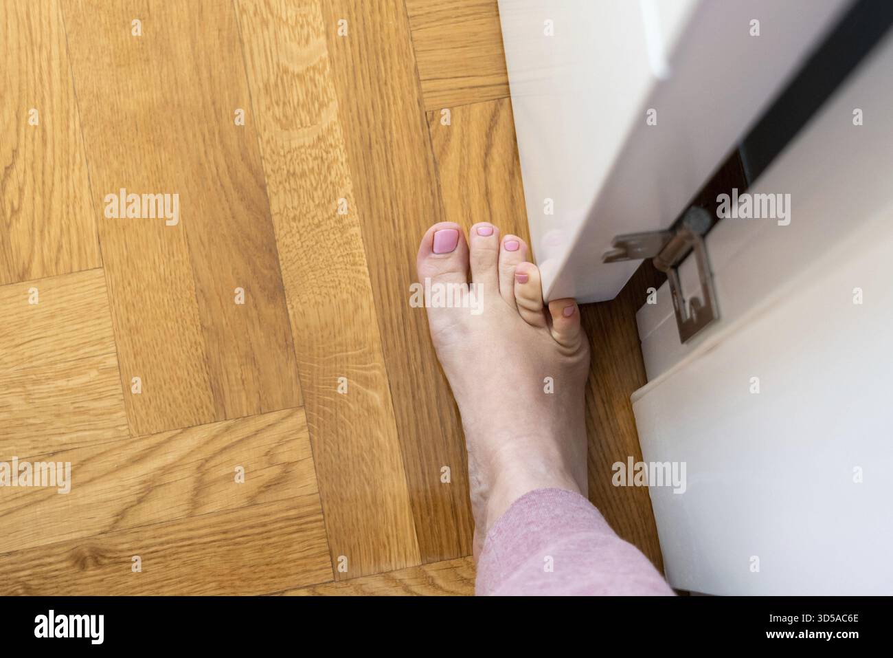 La donna ha colpito i mobili con il piede piccolo. Incidente a casa. Lesione del mignolo del piede Foto Stock