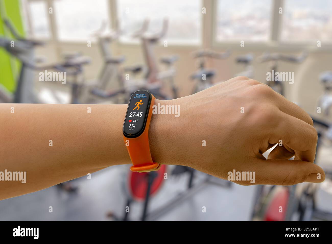 Monitoraggio intelligente della banda dell'attività interna in una palestra moderna, che mostra la durata dell'allenamento, la frequenza cardiaca e le calorie bruciate per il monitoraggio delle prestazioni di fitness Foto Stock
