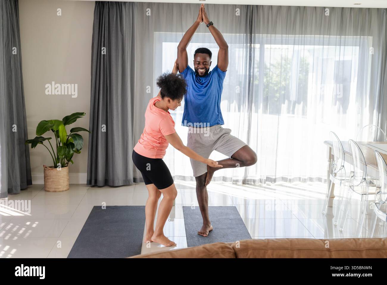 Coppia pratica yoga insieme a casa, godendo di equilibrio e connessione Foto Stock