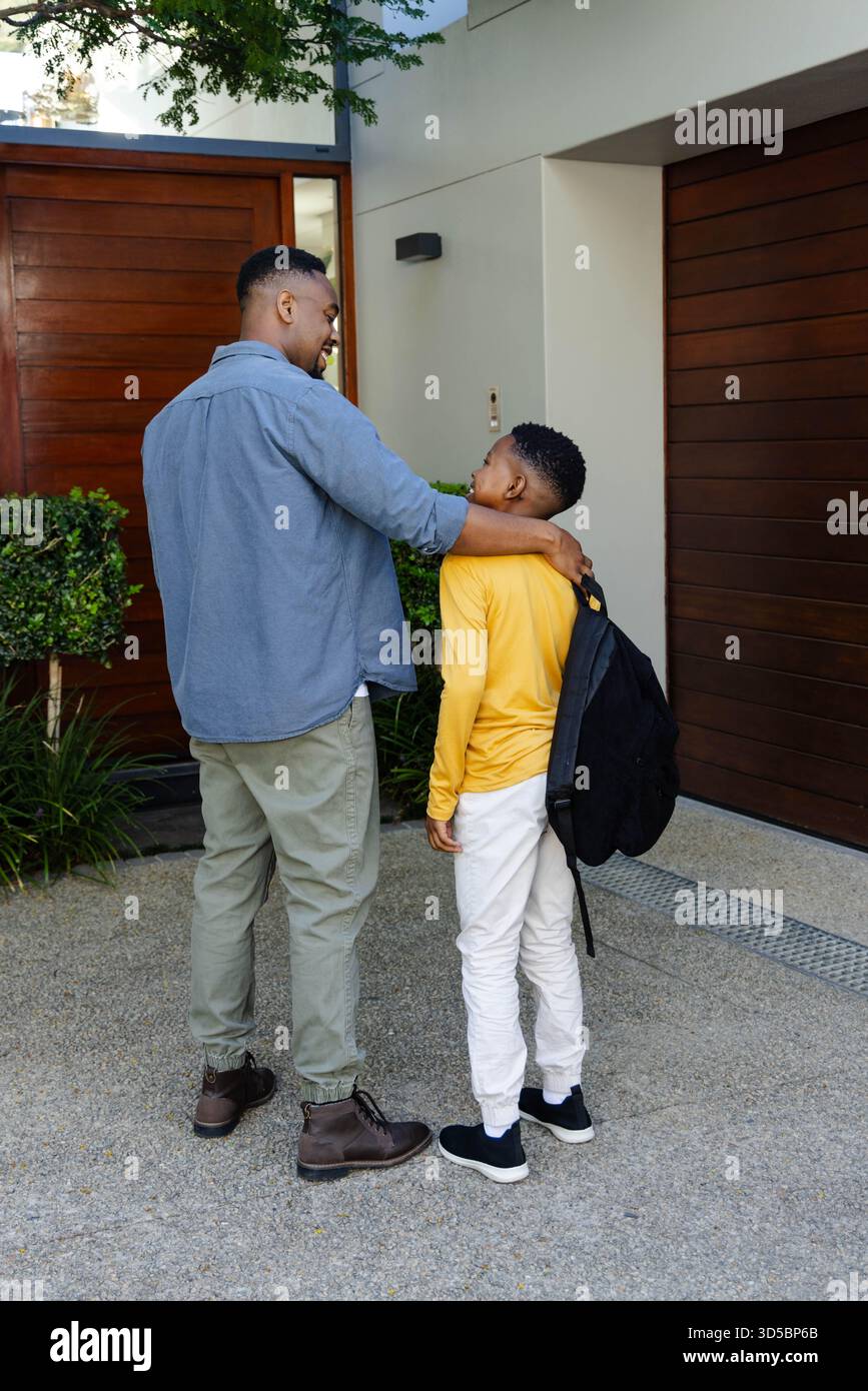 Padre e figlio si legano fuori casa, condividendo momenti prima della scuola Foto Stock