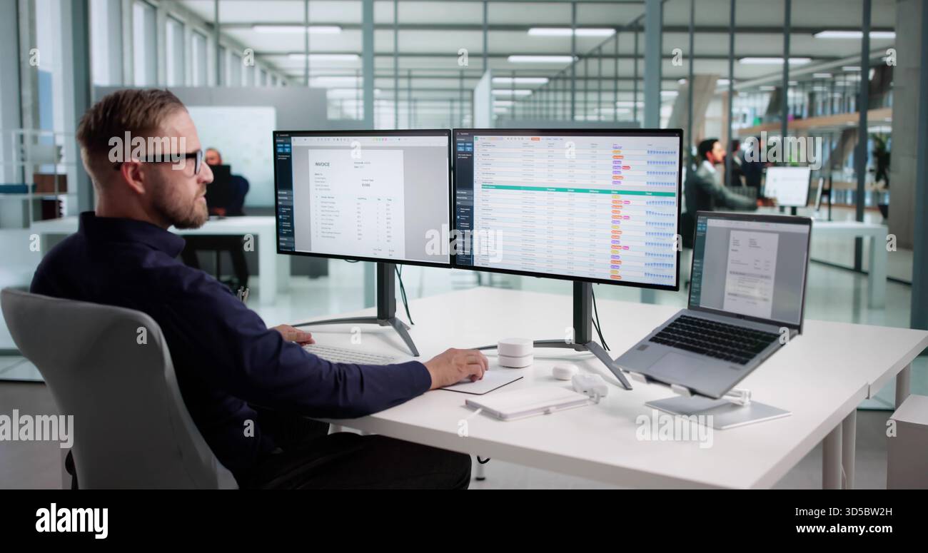 Uomo che utilizza il foglio di calcolo Office per monitorare i codici e i dati di fatturazione medica Foto Stock