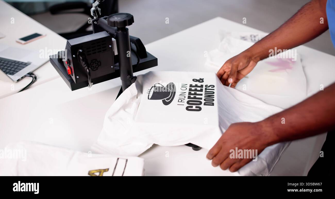 African-American Man Screen Prints maglietta personalizzata con logo alla Heat Press Factory. Foto Stock