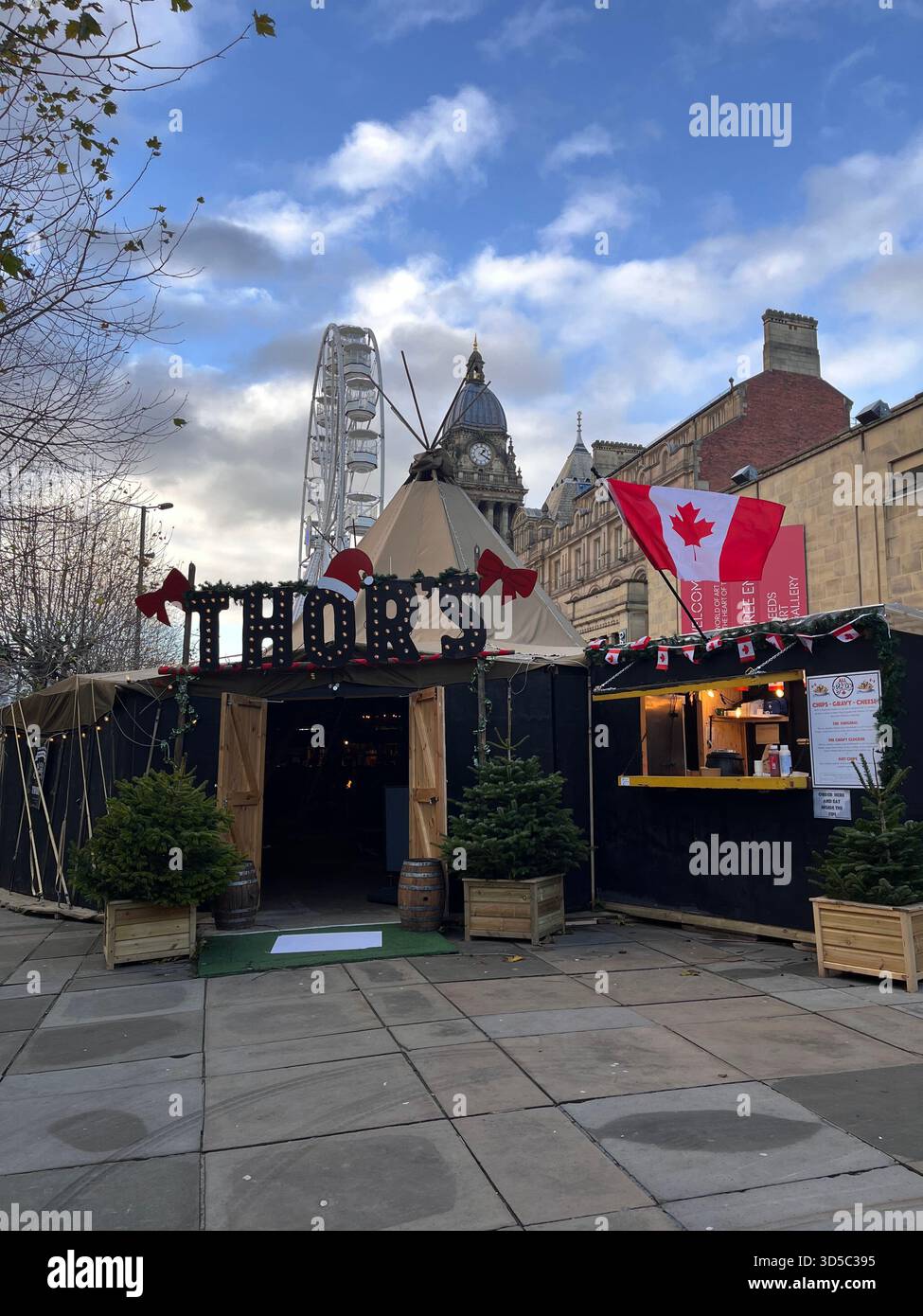 Bancarelle per il mercatino natalizio decorato con luci e bandiere canadesi in una piazza urbana di Hull, Inghilterra. L'atmosfera di Holiday Street Market........ - Immagine stock catturata con smartphone