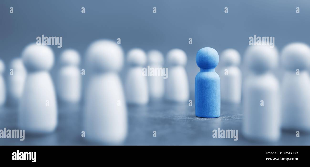 Distinguiti dalla massa, dall'unicità, dalle nuove idee e dal concetto di visione aziendale con un'attenzione selettiva su un'unica figura di pedone blu in legno che spicca. Foto Stock