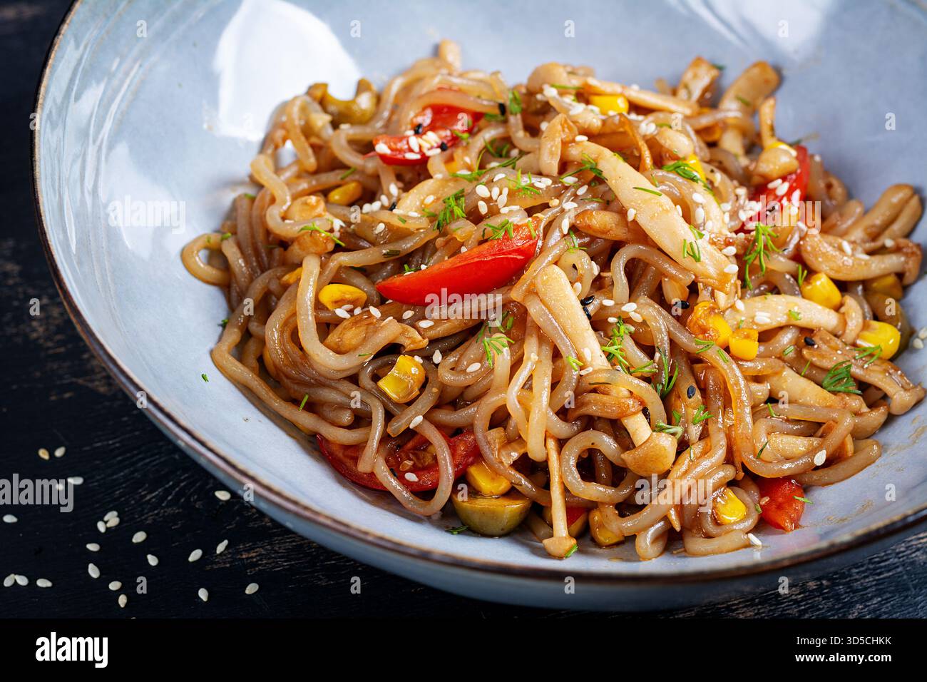 Gli spaghetti Shirataki saltano in salsa di soia piccante. Tagliatelle Shirataki con funghi shimeji. Cucina asiatica. Foto Stock