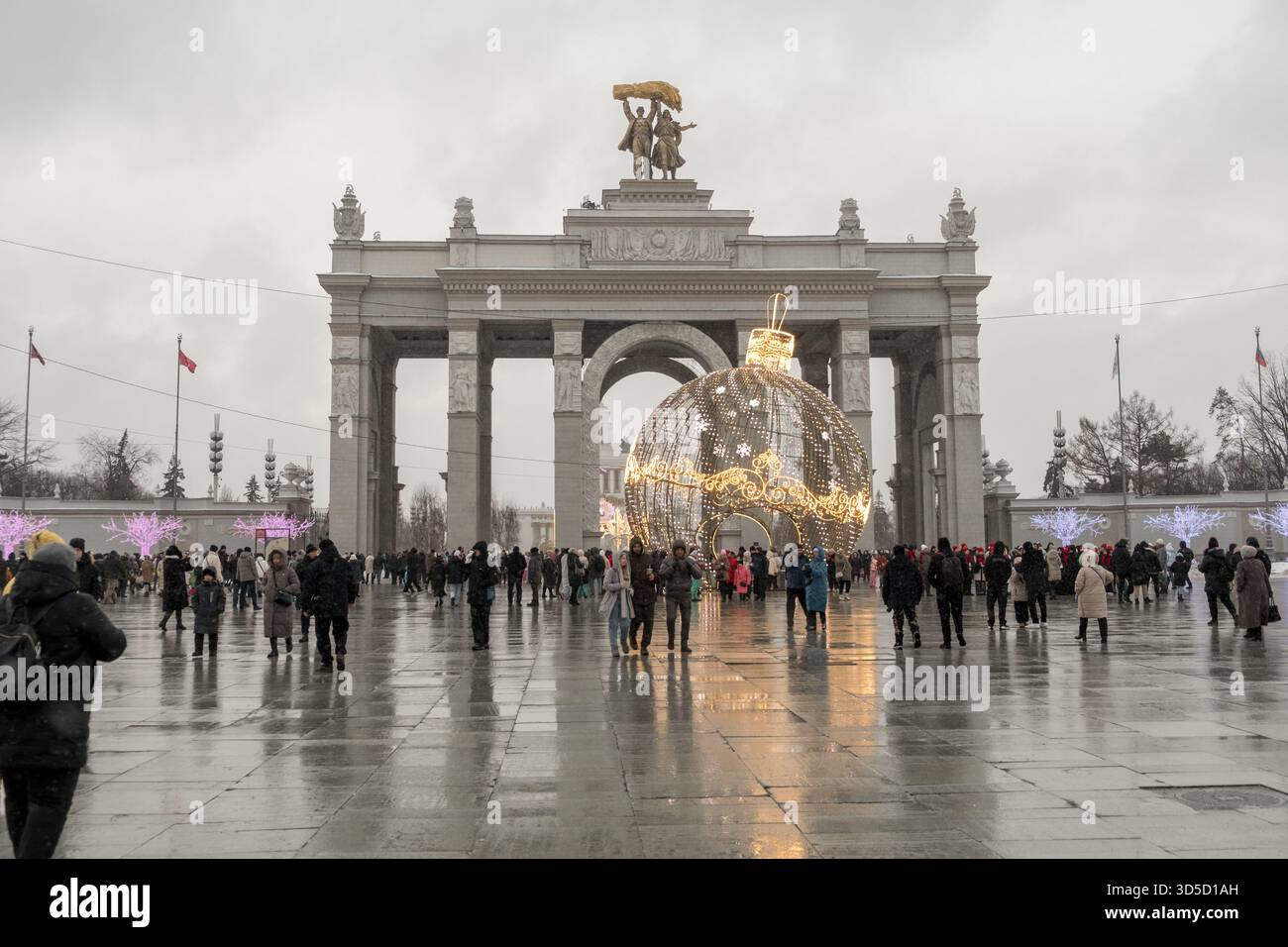 La grande decorazione festiva attira la folla al VDNH Park durante la celebrazione invernale a Mosca, in Russia, in un giorno di pioggia Foto Stock