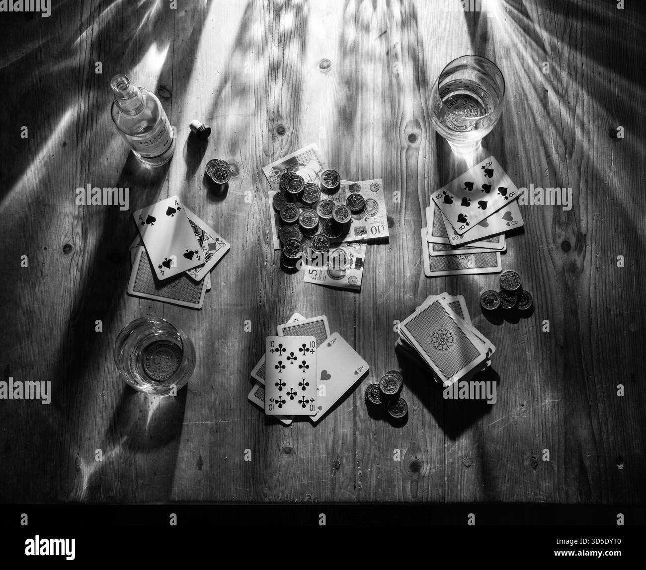 MAZZO DI CARTE DEL GIOCO DI CARTE CINQUE STUD DI CARTE PINE DA TAVOLO BICCHIERI DI WHISKY BOTTIGLIA VUOTA DI PENTOLA TALISKER AL CENTRO DEL CAPPELLO DA BOWLER E DELLA GIACCA SULLA SEDIA Foto Stock