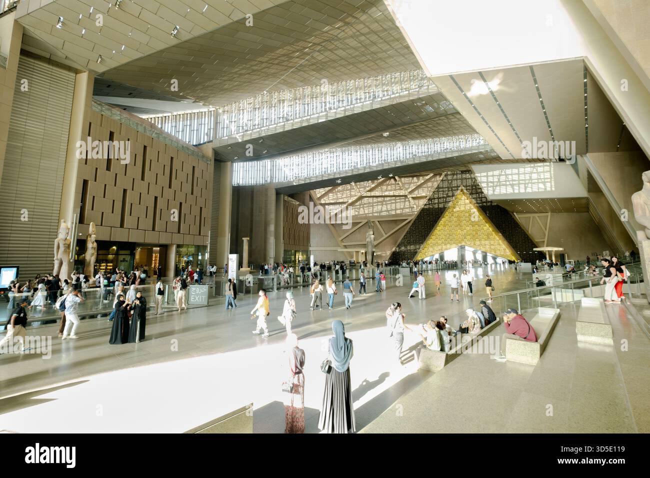Sala del Grand egyptian Museum piena di persone che esplorano l'architettura moderna e i manufatti egizi, il Cairo, l'Egitto Foto Stock