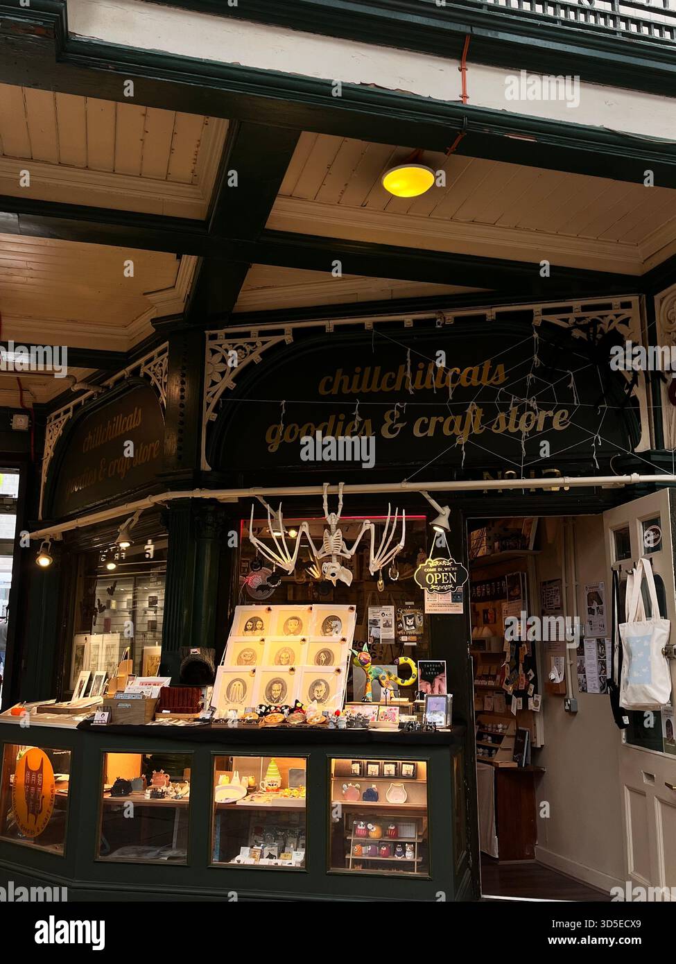 Un intimo negozio di artigianato e articoli da regalo situato all'interno di uno storico mercato coperto di Leeds. Illuminazione calda, oggetti fatti a mano e architettura tradizionale - Immagine stock catturata con smartphone