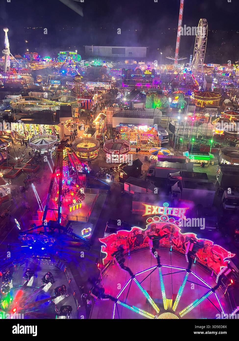Una vivace vista notturna della Hull Fair, una delle più grandi fiere di divertimento itineranti d'Europa, con attrazioni illuminate, giostre, luci colorate, - Immagine stock catturata con smartphone