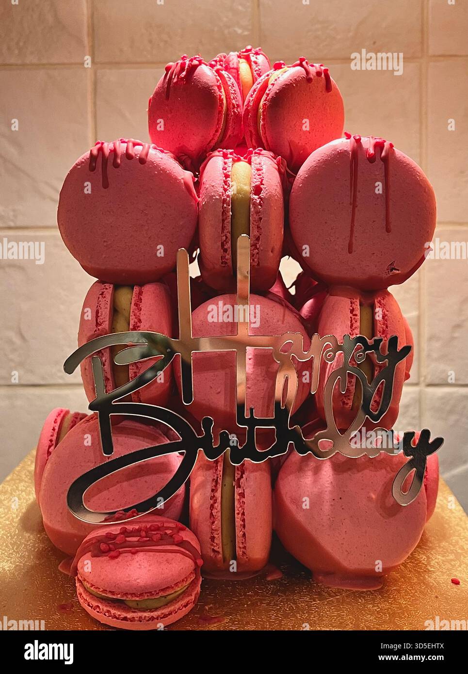 Un'alta torre di macaron rosa decorata per una festa di compleanno. L'elegante dessert presenta macaron rosa assortiti disposti ordinatamente su una base di torte. - Immagine stock catturata con smartphone
