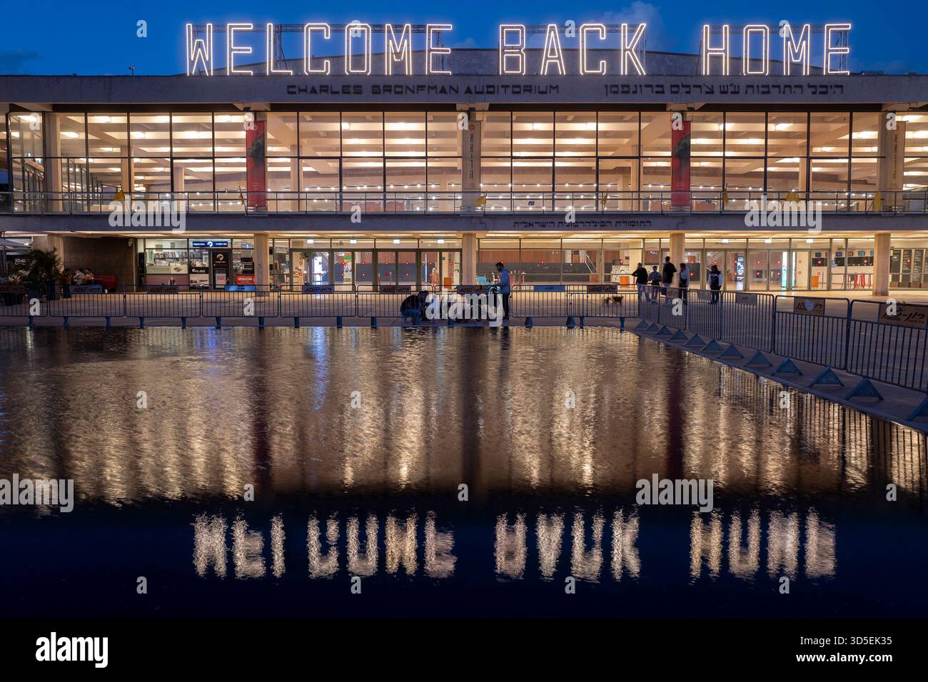 Tel Aviv, Israele. 15 novembre 2025. Civili israeliani visti davanti al Charles Bronfman Auditorium, che si trova accanto al Mann Auditorium, in Piazza Habima a Tel Aviv, Israele, mentre il grande cartello "Welcome Back Home" si illumina al tramonto di sabato 15 novembre 2025. Israele attende gli ultimi tre cadaveri che gli Hamas dovrebbero tornare per completare la prima fase del piano di pace sostenuto dagli Stati Uniti tra Israele e le forze di Hamas. La fase 2, quando avrà inizio, sarà cruciale, in quanto Hamas dovrebbe disarmarsi. Foto di Jim Hollander/UPI credito: UPI/Alamy Live News Foto Stock