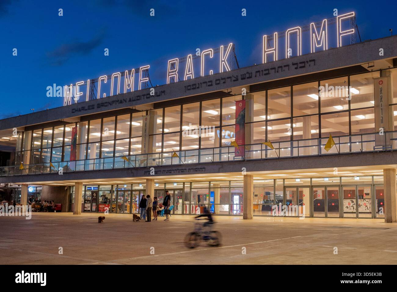 Tel Aviv, Israele. 15 novembre 2025. Civili israeliani visti davanti al Charles Bronfman Auditorium, che si trova accanto al Mann Auditorium, in Piazza Habima a Tel Aviv, Israele, mentre il grande cartello "Welcome Back Home" si illumina al tramonto di sabato 15 novembre 2025. Israele attende gli ultimi tre cadaveri che gli Hamas dovrebbero tornare per completare la prima fase del piano di pace sostenuto dagli Stati Uniti tra Israele e le forze di Hamas. La fase 2, quando avrà inizio, sarà cruciale, in quanto Hamas dovrebbe disarmarsi. Foto di Jim Hollander/UPI credito: UPI/Alamy Live News Foto Stock