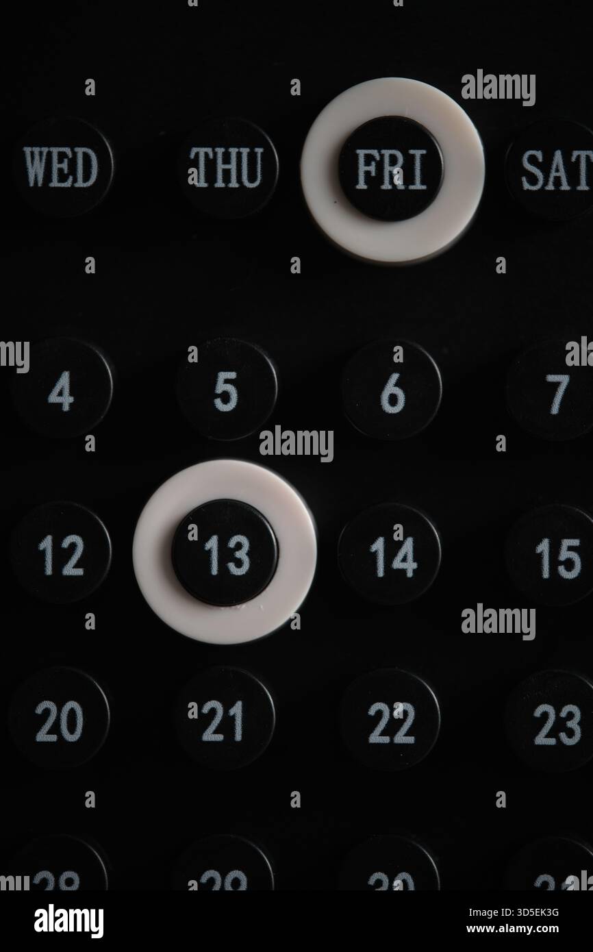 Primo piano del calendario della scrivania con venerdì e numero 13 evidenziati, creando un accento visivo focalizzato e minimalista Foto Stock