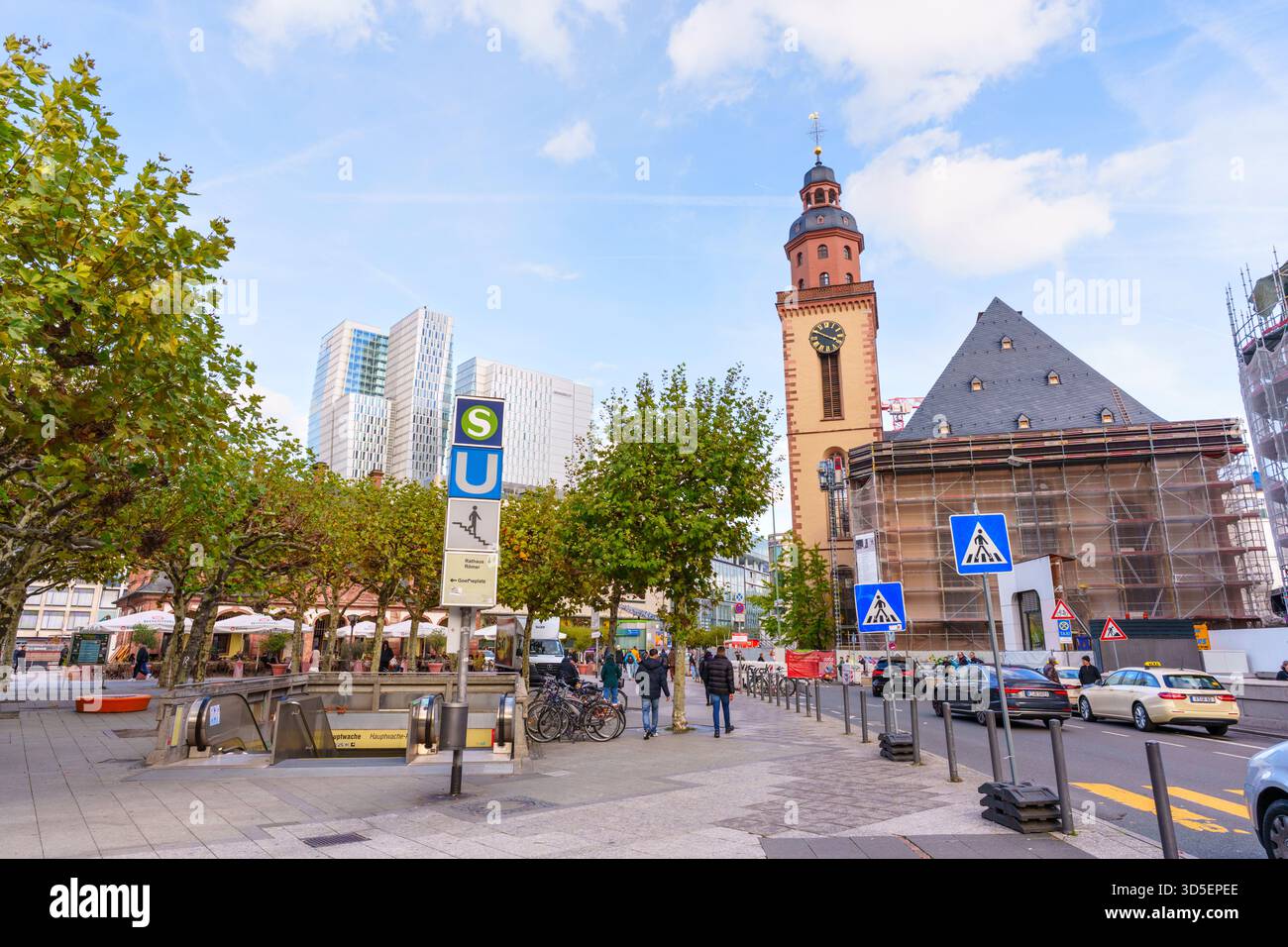 Francoforte, Germania - 21 ottobre 2025: La storica Katharinenkirche, in parte in fase di ristrutturazione, contrasta con i moderni grattacieli e il trambusto Foto Stock