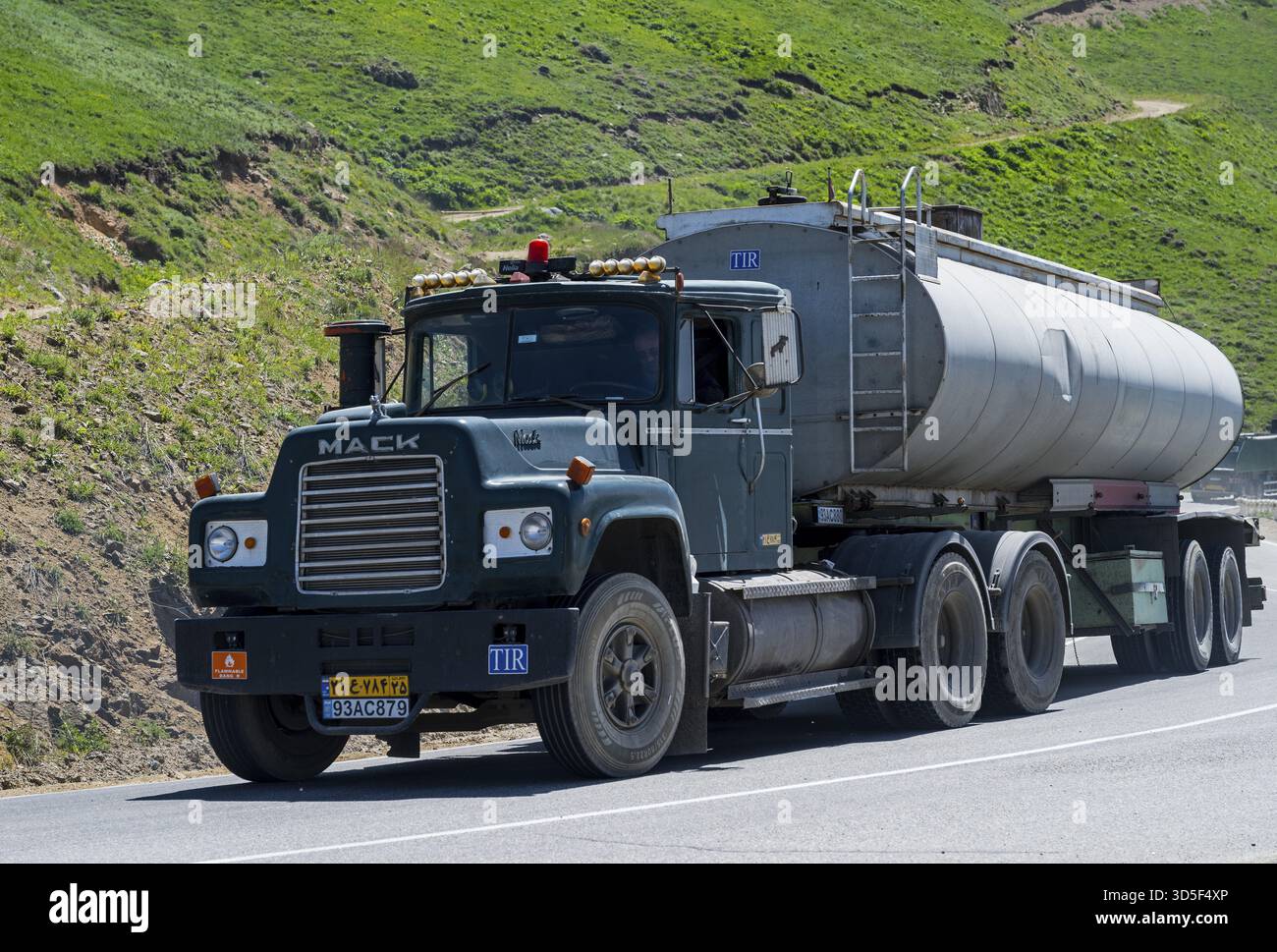 Un camion verde con rimorchio per cisterne sta guidando su una strada di montagna, Mack Truck con targa iraniana su m2 vicino al passo Meghri, al passo Tashtun, a Syunik pr Foto Stock