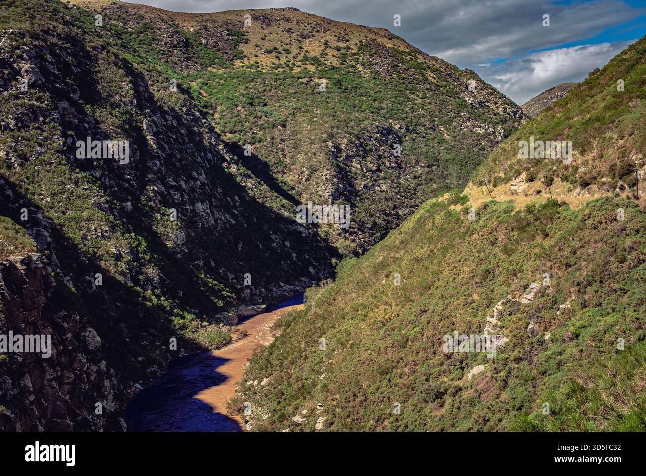 I colori contrastanti del fiume e la vegetazione lussureggiante sui lati delle montagne creano uno splendido paesaggio naturale Foto Stock