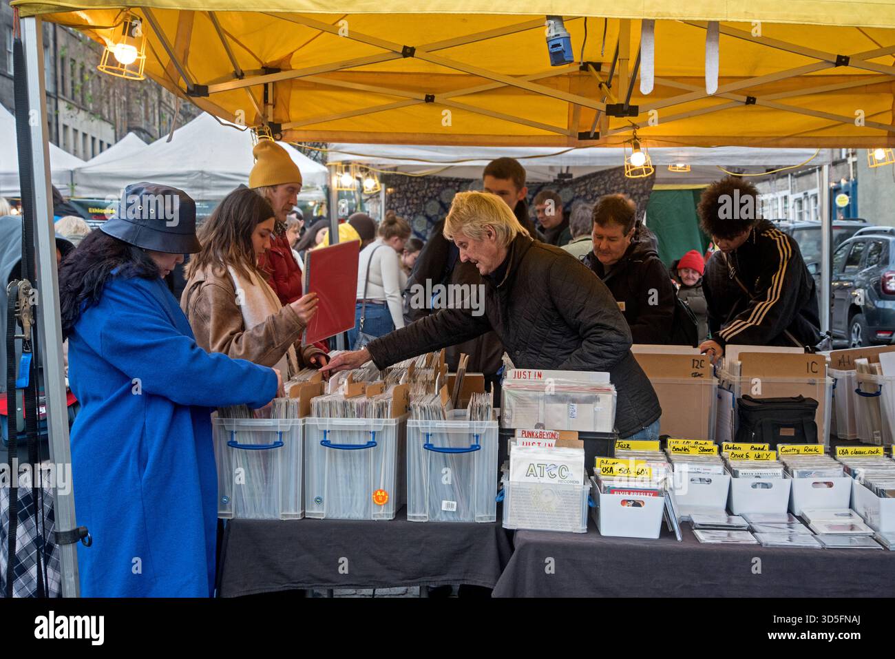 Clienti che sfogliano dischi in vinile in una bancarella al mercato del sabato a Grassmarket, Edimburgo, Scozia, Regno Unito. Foto Stock