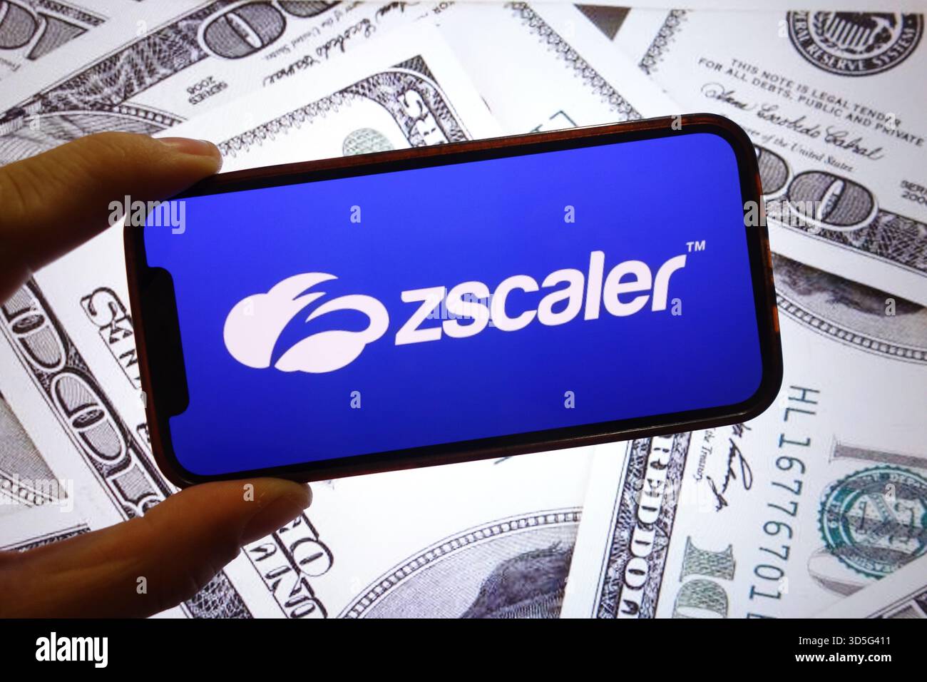 28 settembre 2025, Polonia: In questa foto, il logo della società Zscaler viene visualizzato su uno schermo di uno smartphone con le banconote in dollari statunitensi sullo sfondo. (Credit Image: © Piotr Swat/SOPA Images via ZUMA Press Wire) SOLO PER USO EDITORIALE! Non per USO commerciale! Foto Stock