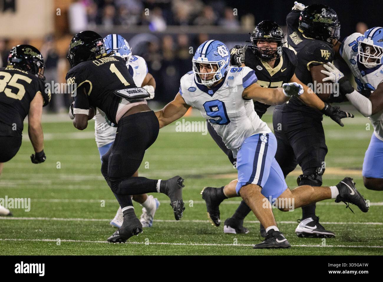 Winston-Salem, North Carolina, Stati Uniti. 15 novembre 2025. Il defensive lineman dei North Carolina Tar Heels Melkart Abou Jaoude (9) afferra il running back dei Wake Forest Demon Deacons Demond Claiborne (1) nel backfield durante la seconda metà della partita di football ACC all'Allegacy Stadium di Winston-Salem, North Carolina. (Scott Kinser/CSM). Crediti: csm/Alamy Live News Foto Stock