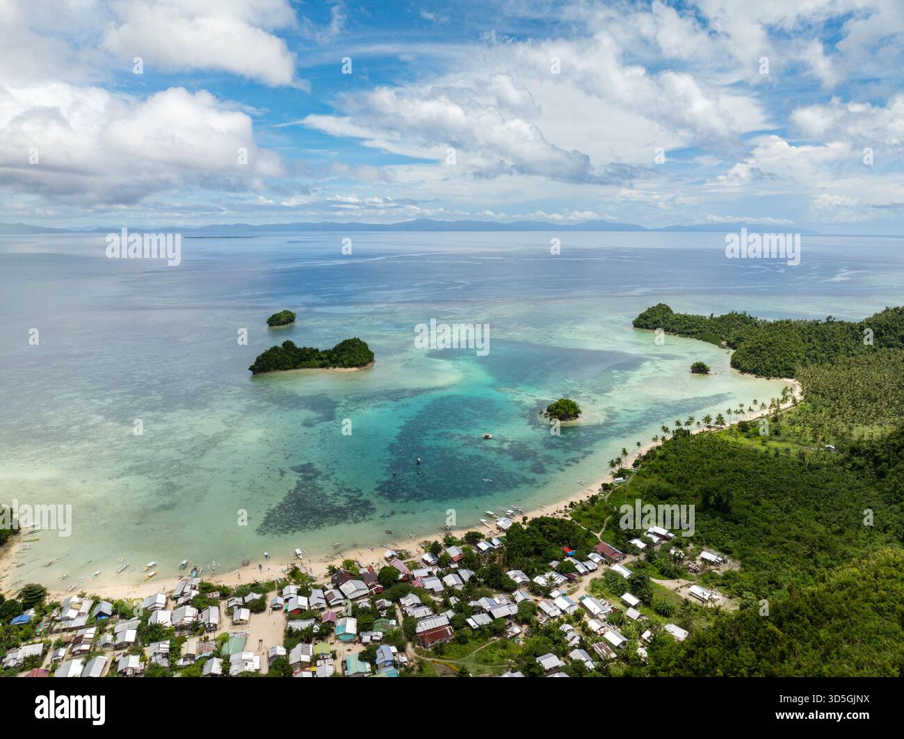 Villaggio sulla spiaggia con laguna turchese e barriera corallina in acque tropicali cristalline. Siargao, Filippine. Laguna blu di Sugba. Foto Stock