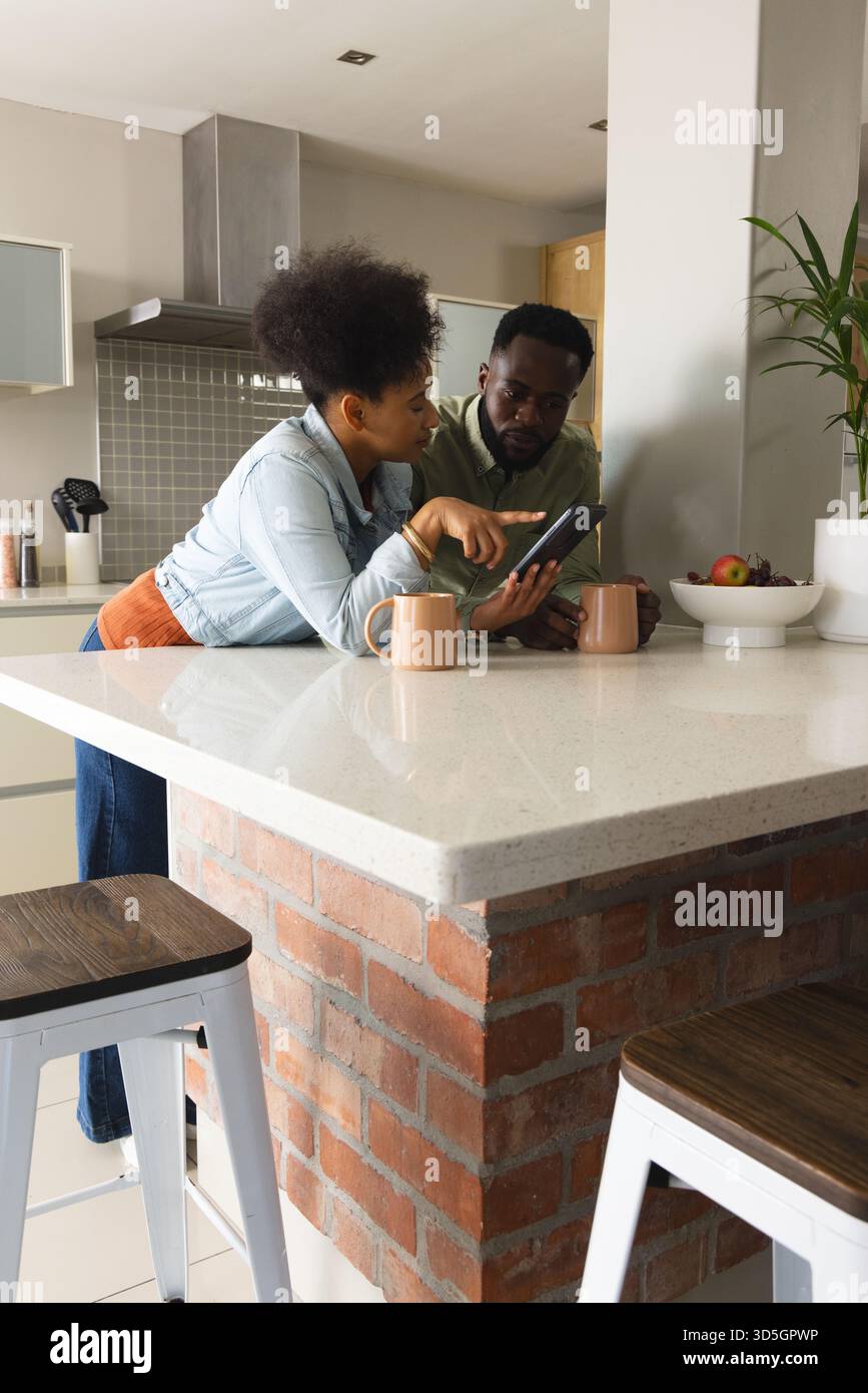 Coppia afroamericana che discute qualcosa su un tablet nella cucina moderna Foto Stock